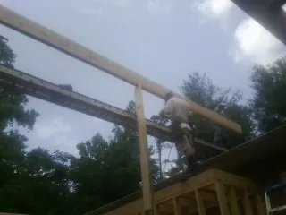 Carpenter setting a ridge beam over a new addition frame — Ice Dam Removal by Roofing Brothers in Fox River Grove