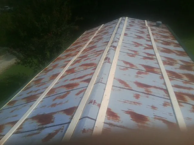 Rusted metal roof panels with new wood purlins before replacement — Storm Damage Roof Repair in Fox River Grove by Roofing Brothers